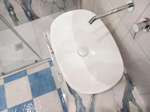 a white sink in a bathroom with a shower at Damè Mare in Maiori