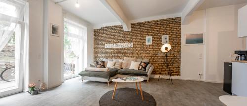 a living room with a couch and a brick wall at Loftdesign 7 Personen Boxspring Frankenthal Ludwigshafen BASF in Frankenthal