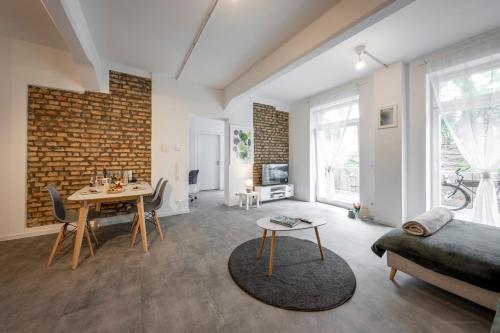 a living room with a brick wall and a table at Loftdesign 7 Personen Boxspring Frankenthal Ludwigshafen BASF in Frankenthal