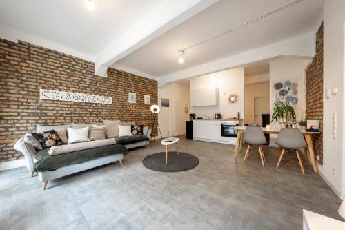 a living room with a couch and a brick wall at Loftdesign 7 Personen Boxspring Frankenthal Ludwigshafen BASF in Frankenthal