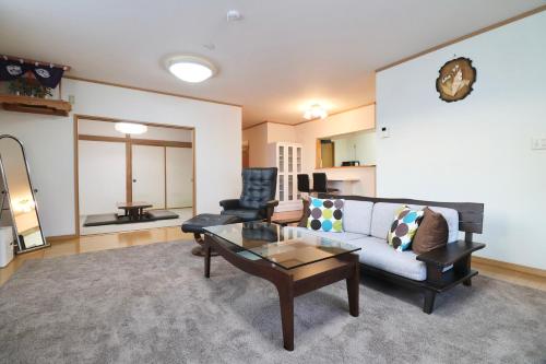 a living room with a couch and a table at Relax House Misato in Shiraoi