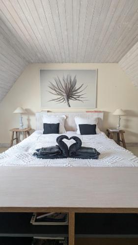 - un grand lit blanc avec 2 serviettes dans l'établissement Charmant cottage normand avec vue panoramique sur la côte de Regnéville, à Regnéville-sur-Mer