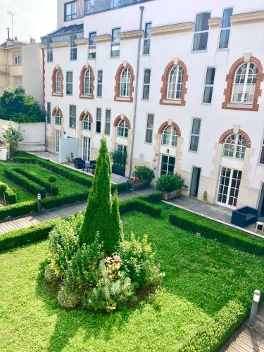 un jardin devant un immeuble dans l'établissement So Guest- Luxueux appartement, ancienne maison de champagne proche Cathédrale, à Reims