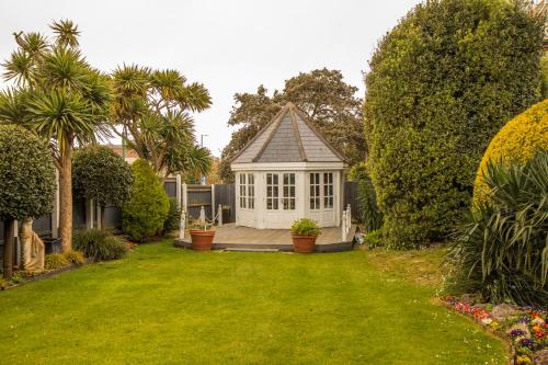 a small white house with a lawn and trees at Royal Bath Hotel & Spa Bournemouth in Bournemouth