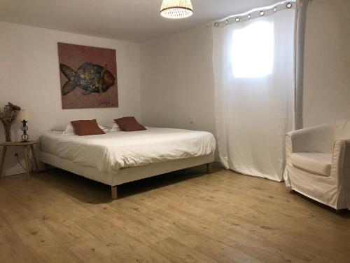 a bedroom with a bed and a chair and a window at Il y a le Soleil, la Campagne et la Mer …1 in Martigues