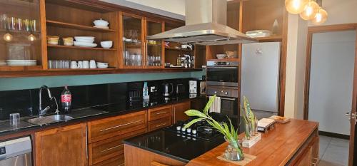 Una cocina con encimera negra y refrigerador. en Villa 24, en Grand Baie