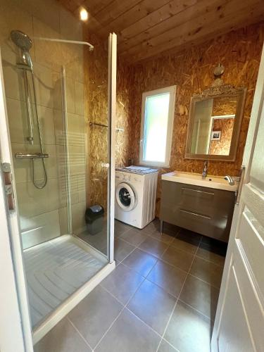 une salle de bain avec douche et machine à laver dans l'établissement Chalet Bois Baobab 5 min à pieds de l'océan, à Montalivet-les-Bains