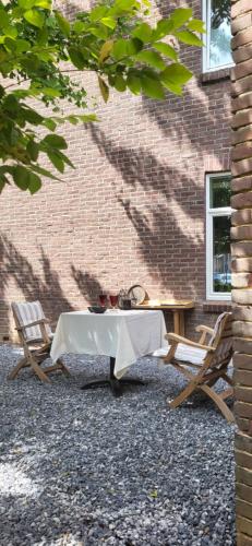 een tafel en twee stoelen voor een bakstenen gebouw bij Mijn appartement met sauna en lift in Voerendaal
