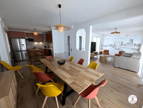 Il dispose d'une cuisine et d'un salon avec une table et des chaises en bois. dans l'établissement Villa Petros, à Les Sables-dʼOlonne