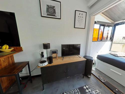 - une chambre avec un bureau, une télévision et un lit dans l'établissement Appart Studio Mezzanine 2 couchages PORT LEUCATE NATURISME PL010-654, à Leucate-Plage