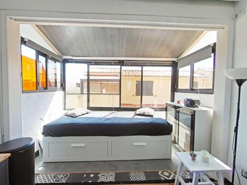 une chambre avec un lit et une grande fenêtre dans l'établissement Appart Studio Mezzanine 2 couchages PORT LEUCATE NATURISME PL010-654, à Leucate-Plage