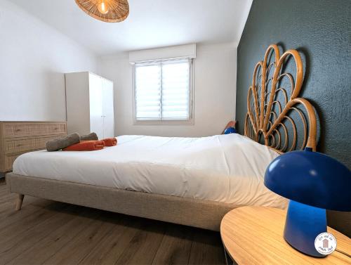 une chambre avec un grand lit avec une tête de lit en bois dans l'établissement Villa Petros, à Les Sables-dʼOlonne