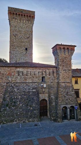 a large brick building with a tower on top of it at CASA VASARI Holiday Suites TUSCANY in Lucignano