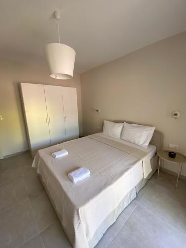 a bedroom with a large bed with two towels on it at Alion houses in Prinos