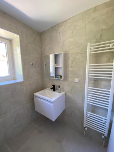 a bathroom with a white sink and a mirror at Alion houses in Prinos