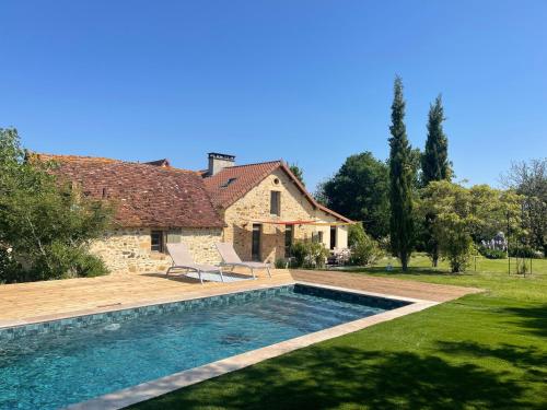 une maison avec une piscine dans une cour dans l'établissement La Ferme Authentique Gîte familiale, à Saint-Sulpice-dʼExcideuil