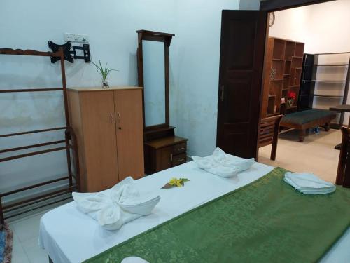 a bedroom with a bed with white sheets and flowers on it at Das Haus Villa & Restaurant in Unawatuna