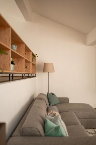 a living room with a brown couch with green pillows at Kuntino Suites in Merano