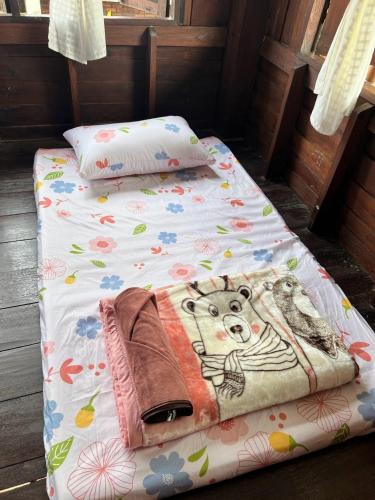 a small bed with a teddy bear on it at The Se Ba Homestay & Hostel at Mae Chaem เด๊อะเซ่บะ โฮมสเตย์ แม่แจ่ม in Mae Chaem
