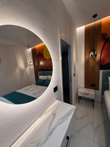 a bedroom with a bed with a round mirror at Vila La Familia in Ksamil