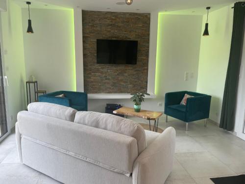 - un salon avec un canapé blanc et deux chaises dans l'établissement Gîte spacieux et calme proche de La Flèche, idéal pour familles - FR-1-410-470, à Villaines-sous-Malicorne