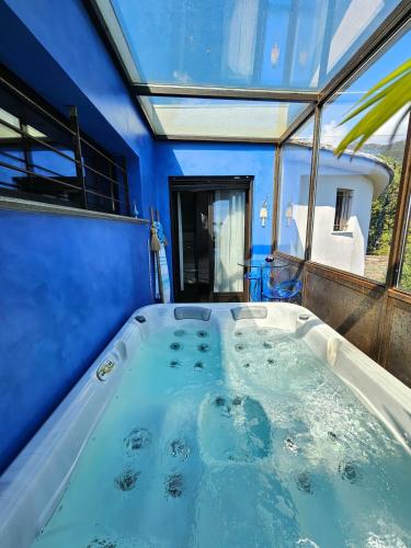 une baignoire jacuzzi dans une chambre aux murs bleus dans l'établissement Villa Prestige Erbalunga - Casa di a Scala, à Brando