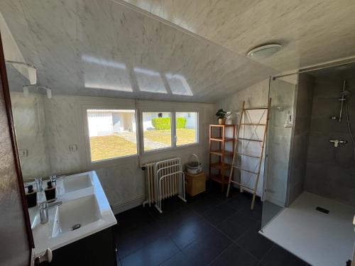 une salle de bain avec un lavabo, une douche et un miroir dans l'établissement Maison de famille à 300m de la plage, à Saint-Jean-de-Monts