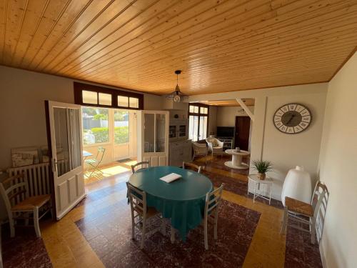 une salle à manger avec une table et des chaises vertes dans l'établissement Maison de famille à 300m de la plage, à Saint-Jean-de-Monts