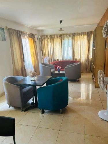 a living room with a table and chairs and a couch at ZUNOX GUEST HOUSE in Freetown