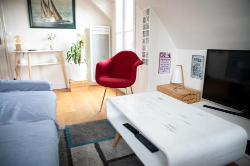 - un salon avec un canapé et un fauteuil rouge dans l'établissement Superbe Apt Cosy Proche Jardin Luxembourg, à Paris