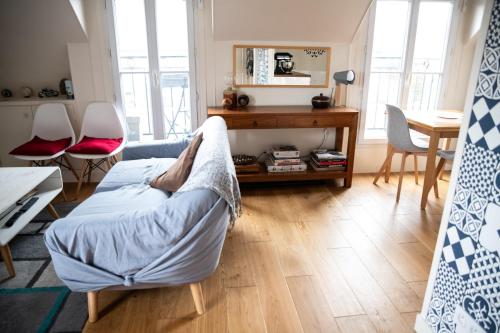 un salon avec un lit, une table et des chaises dans l'établissement Superbe Apt Cosy Proche Jardin Luxembourg, à Paris
