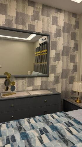 a bedroom with a bed and a mirror on a wall at Luxury Sweet Apartments in Bahira town Lahore in Lahore
