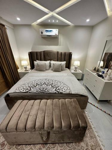 a bedroom with a large bed with a large headboard at Luxury Sweet Apartments in Bahira town Lahore in Lahore