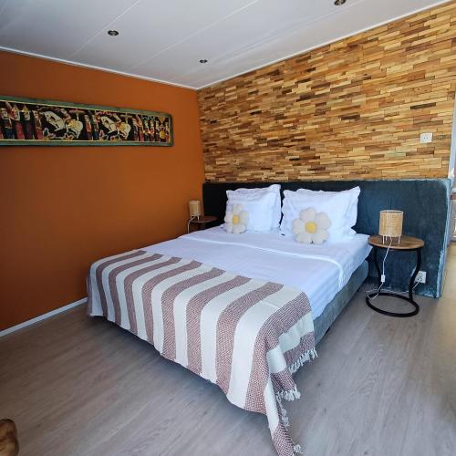 a bedroom with a bed and a brick wall at East Meets West Bed and Breakfast in Veenendaal