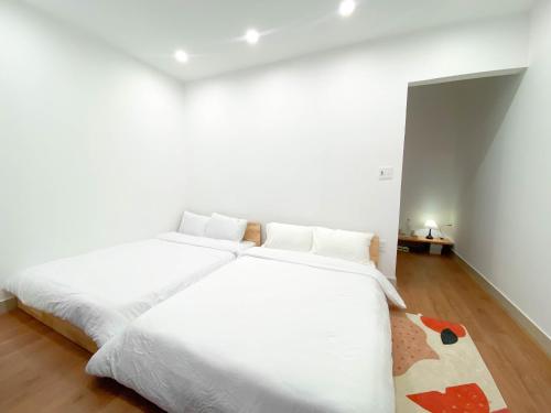 a white bedroom with a large white bed at Chiri Homestay in Thôn Trường Giang