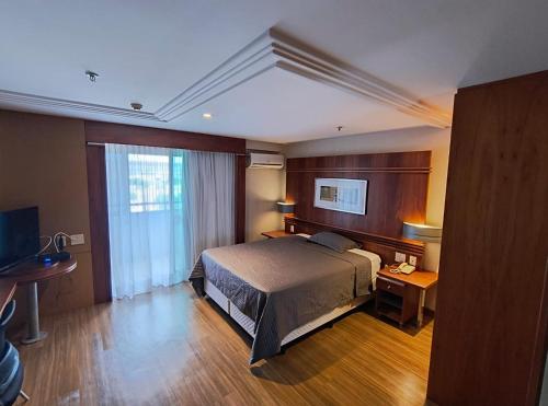 巴西利亚Flat particular no Hotel Grand Mercure com varanda, garagem e wi-fi的一间有床和窗户的酒店房间