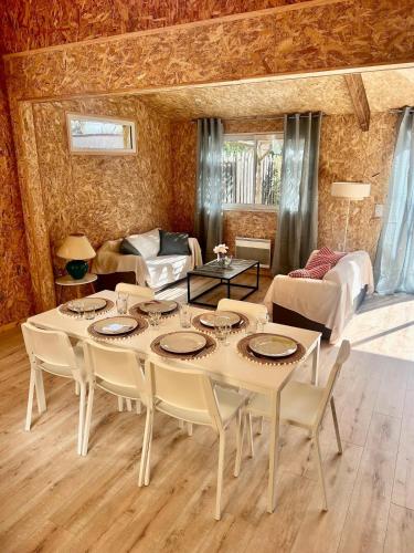 une salle à manger avec une table et des chaises dans une pièce dans l'établissement Chalet Bois Surf 5 min à pieds de l'océan, à Montalivet-les-Bains