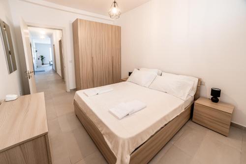 una camera da letto con un letto grande con lenzuola bianche di Sliema 3 bedroom Apartment a Sliema