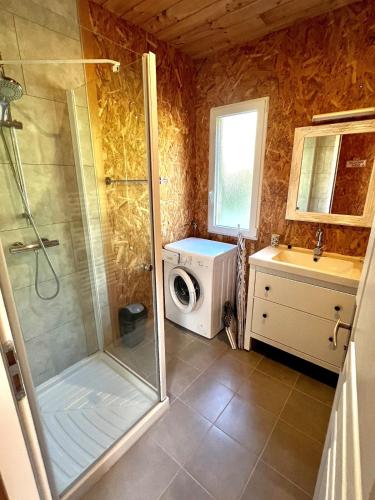 une salle de bain avec douche et machine à laver dans l'établissement Chalet Bois Surf 5 min à pieds de l'océan, à Montalivet-les-Bains