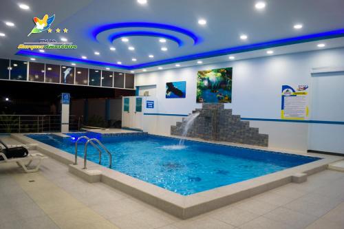 a large swimming pool with a fountain in a building at Hotel Marques Amazonico in Nueva Loja