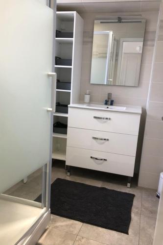 une salle de bain avec un lavabo blanc et un miroir dans l'établissement Maison avec piscine privée chauffée, à La Guérinière