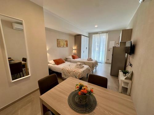a hotel room with two beds and a table with flowers on it at Legni di mare residence in San Salvatore