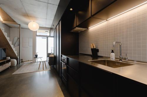 a kitchen with a sink and a counter top at NYC Loft Vibe! 2BR City Stay w Rooftop Terrace in Wellington