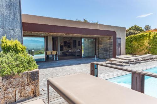 une maison avec une terrasse et une piscine dans l'établissement Villa Paolina, à Sainte-Lucie de Porto-Vecchio