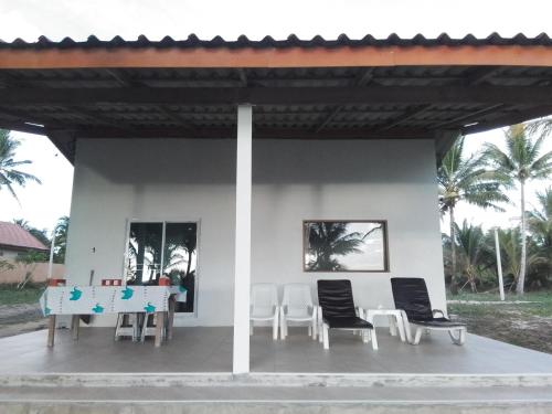 a house with a table and chairs on a patio at The Rock Coco Villa in Ban Laem Pom