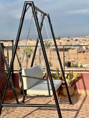 einen Schaukelstuhl auf einem Balkon mit Aussicht in der Unterkunft Apartment with rooftop access in Marrakesch