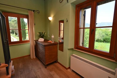a room with green walls and windows and a wooden dresser at Villa al Furlo con Idromassaggio in Pagino