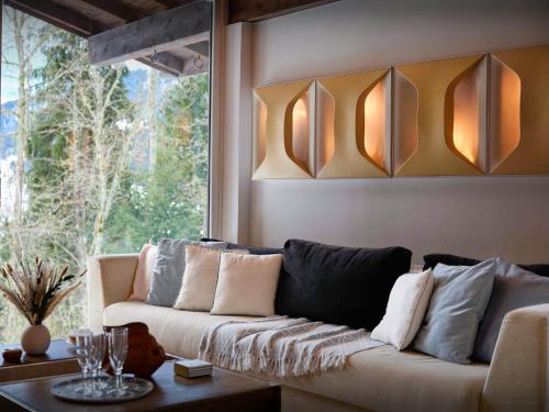 un salon avec un canapé et une fenêtre dans l'établissement Chalet Jorat - OVO Network, aux Contamines-Montjoie