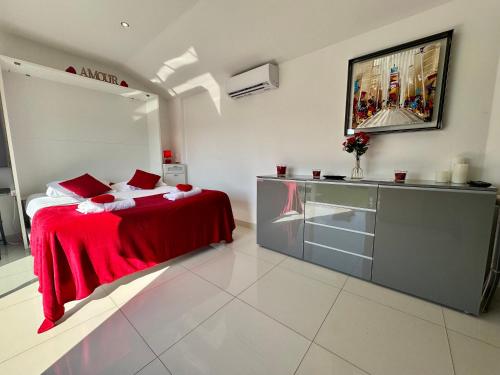 une chambre avec un lit avec une couverture rouge dans l'établissement Studio Love Room Rooftop Jacuzzi SCLS Rentals, à Cannes