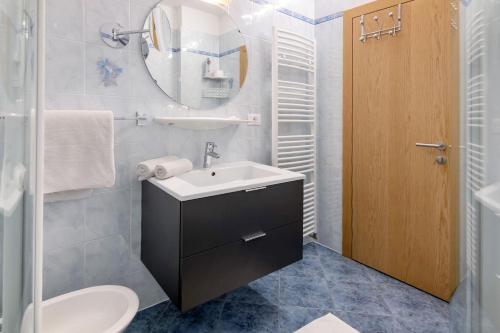 a bathroom with a sink and a toilet and a mirror at Haus Christine in Rifiano